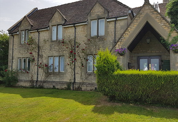 two story house with stone exterior and vegetation in front featuring 16 roses and a well maintained lawn