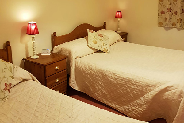 cozy bedroom with two beds nightstand and lamps