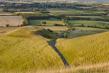 lush green hills with a winding road and fields in the background showcasing beautiful countryside scenery perfect for nature lovers and outdoor enthusiasts includes the number 9 in the distance
